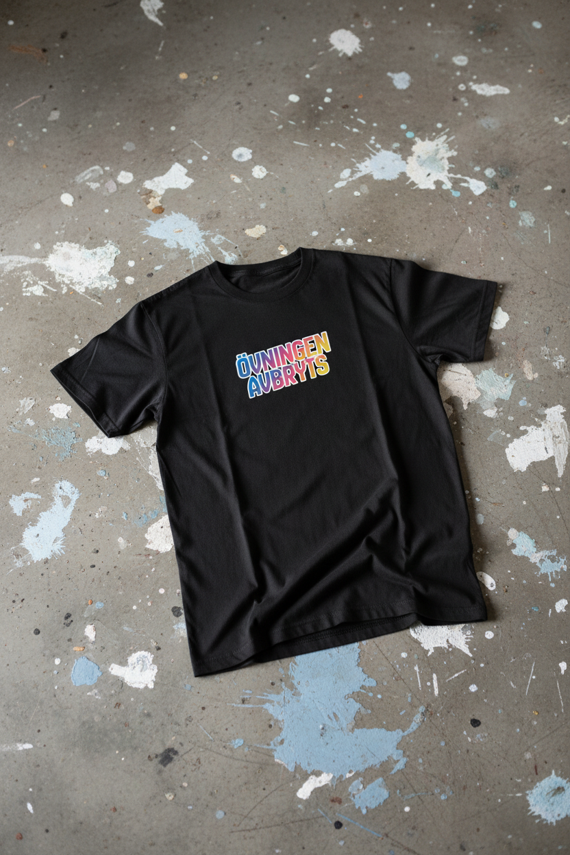 T-shirt Övningen Avbryts – framsida, betonggolv